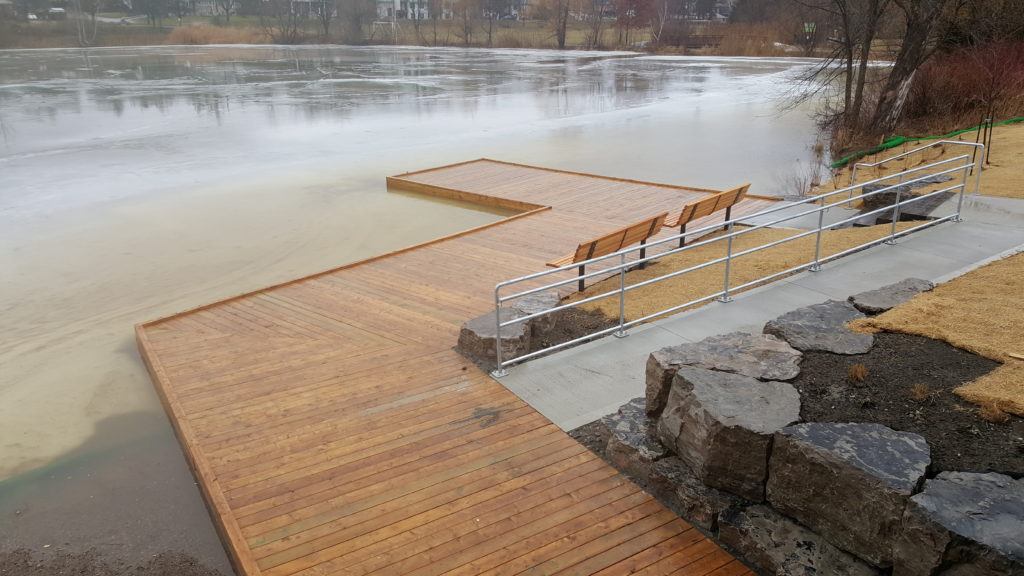 Landscape image of an accessible dock on the shoreline of Fairy lake with 2 benches and railings